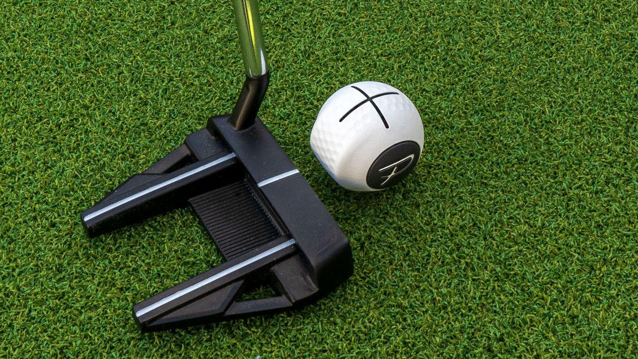 A putter on a green sat behind the PuttOut Devil Ball