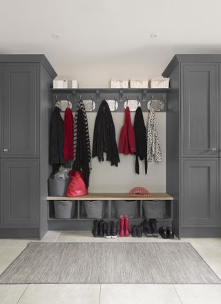mudroom with grey fitted cabinets, hooks, and bench with storage underneath
