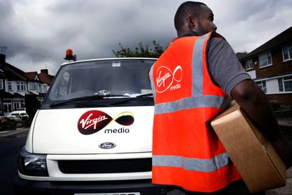 A Virgin Media employee delivering a digital tv receiver