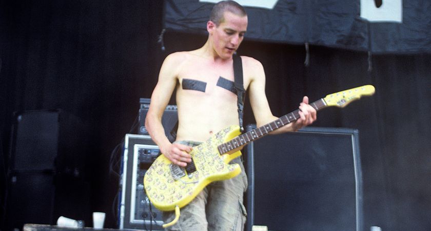 Richard Patrick of Nine Inch Nails performs shirtless with electrical tape over his nipples during the industrial-rock band&#039;s set at Lollapalooza 1991. He plays a single-pickup G&amp;L electric guitar.