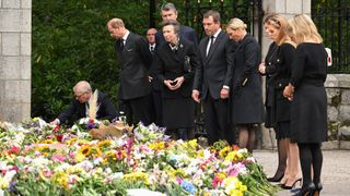 Prince Andrew, Duke of York, Prince Edward, Earl of Wessex, Anne, Princess Royal, Peter Phillips, Princess Eugenie, Princess Beatrice, Sophie, Countess of Wessex and Lady Louise Windsor look at flowers left by the public outside the gates of Balmoral Castle