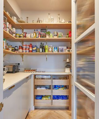 walk in pantry with wooden shelving, pale grey units and brightly lit room