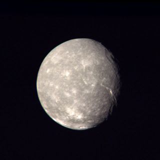 This image of Titania, taken by the Voyager 2 probe, shows the cratered surface of Uranus' moon.