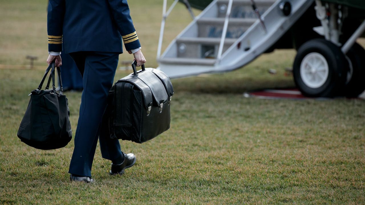 A military aide carries the &amp;#039;nuclear football&amp;#039;, which travels with the president at all times 