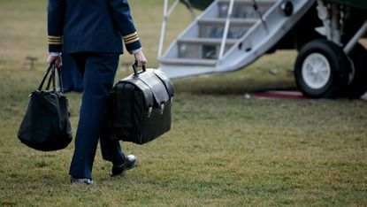 A military aide carries the 'nuclear football', which travels with the president at all times 