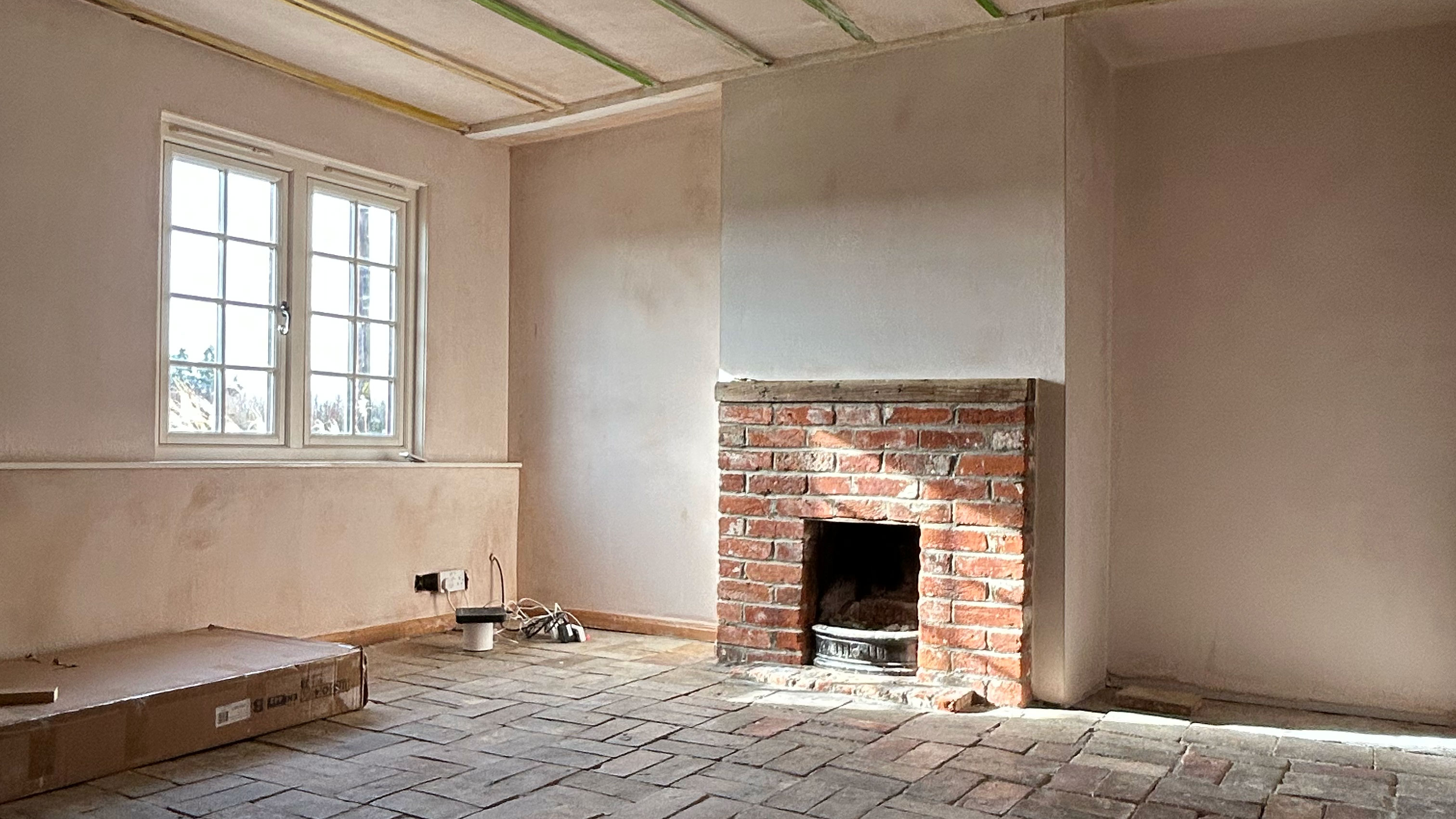 Room mid-reno with bare walls, ceiling and stone-tiled floor