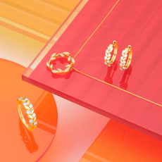 Gold and diamond rings on pink and orange background