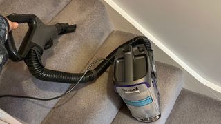The main section of the Shark Anti Hair Wrap Upright Vacuum Cleaner with Powered Lift-Away NZ850UK being used to clean stairs