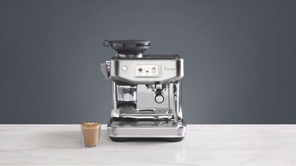 A Sage coffee machine with a coffee next to it