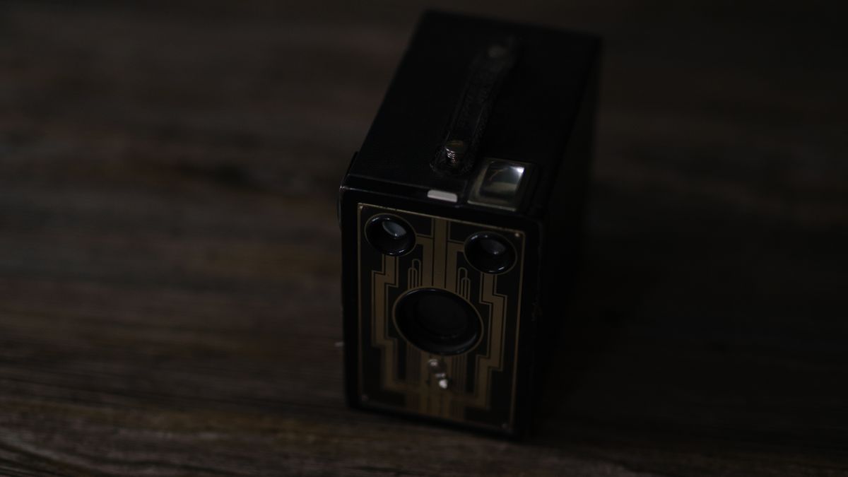 A photo of a vintage box camera taken under different lighting conditions