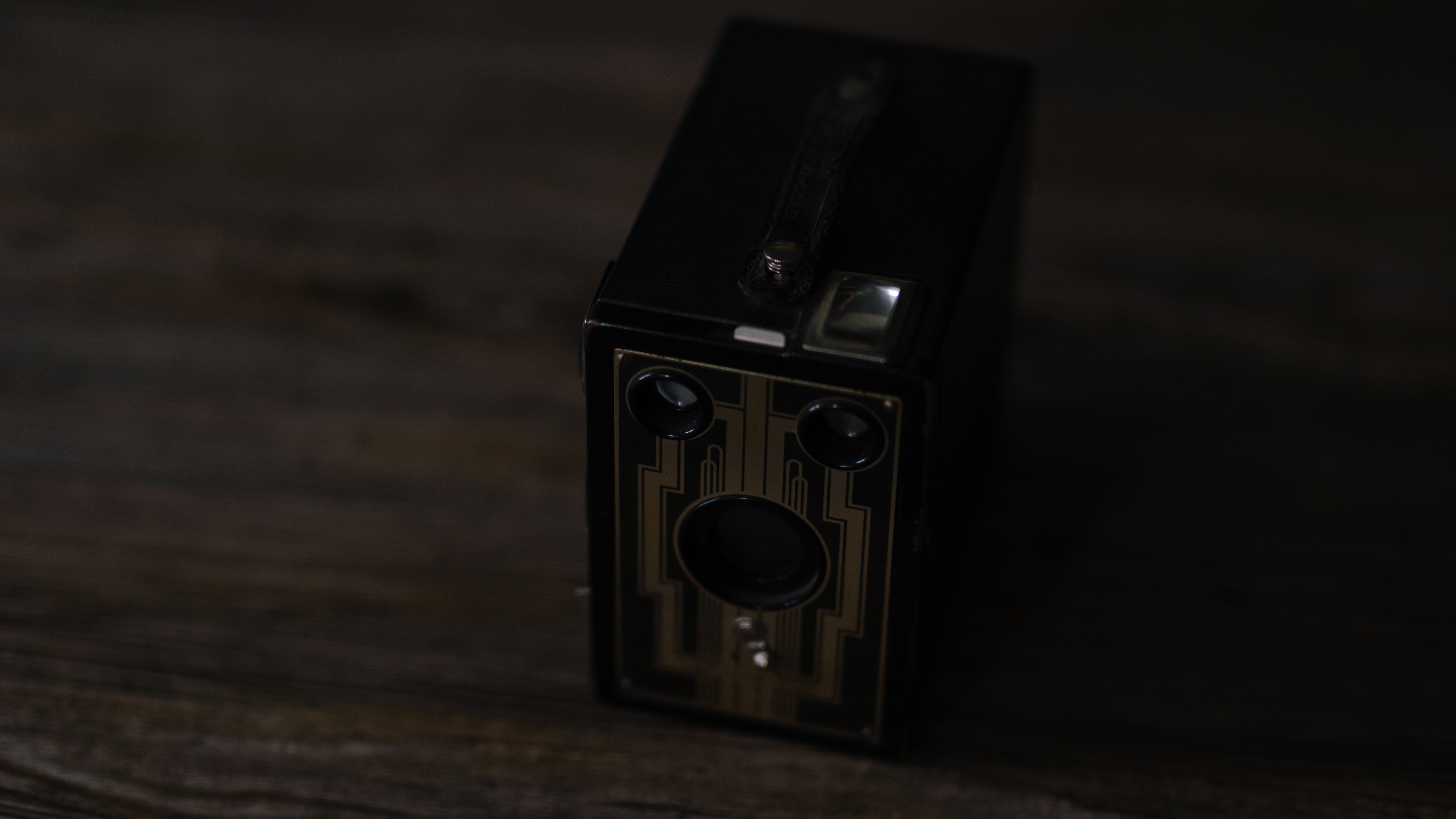 A photo of a vintage box camera taken under different lighting conditions