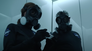 Two people wearing gas masks during the heist
