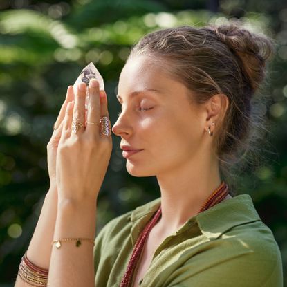Woman holds crystal in garden