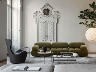 A modern living room featuring an olive green modular sofa designed by Mario Bellini