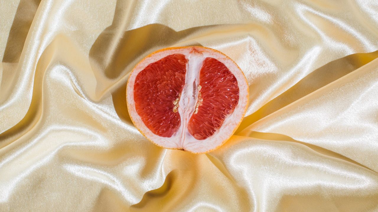 grapefruit on white satin sheets