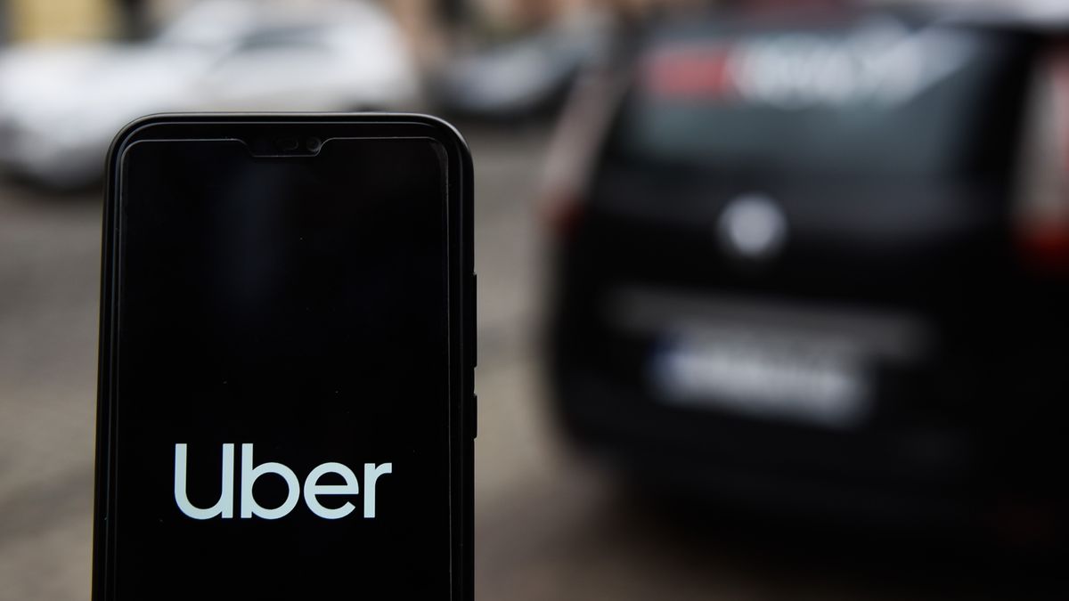 Uber app open a phone next to a car