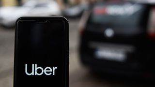Uber app open a phone next to a car
