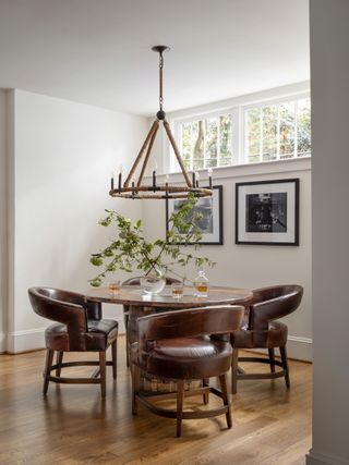 A round dining table with leather dining chairs around it