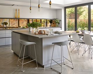 A large kitchen with l-shaped kitchen island and bar stools