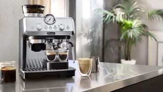 The De'Longhi La Specialista Arte espresso machine on a countertop surrounded by coffee