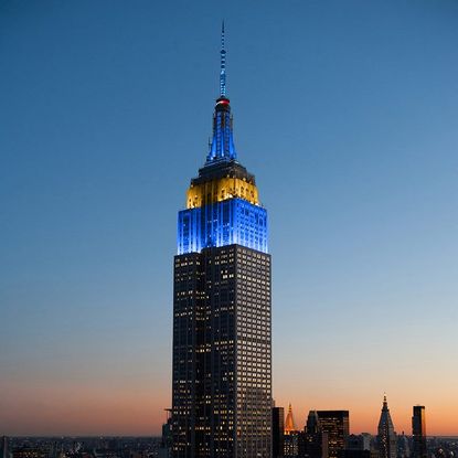 The Empire State Building lit up in blue and yellow.