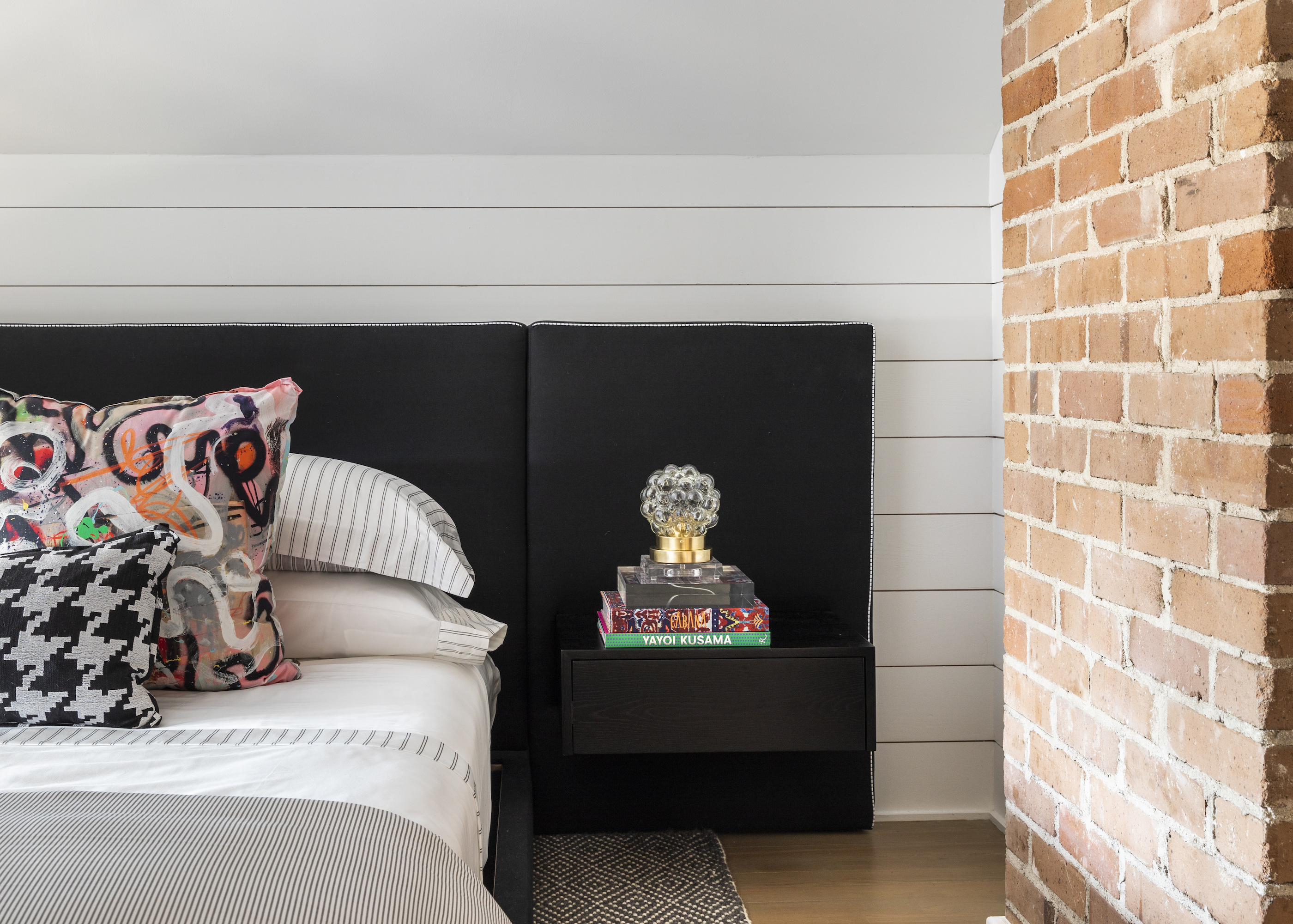 loft conversion with bed and exposed brick wall