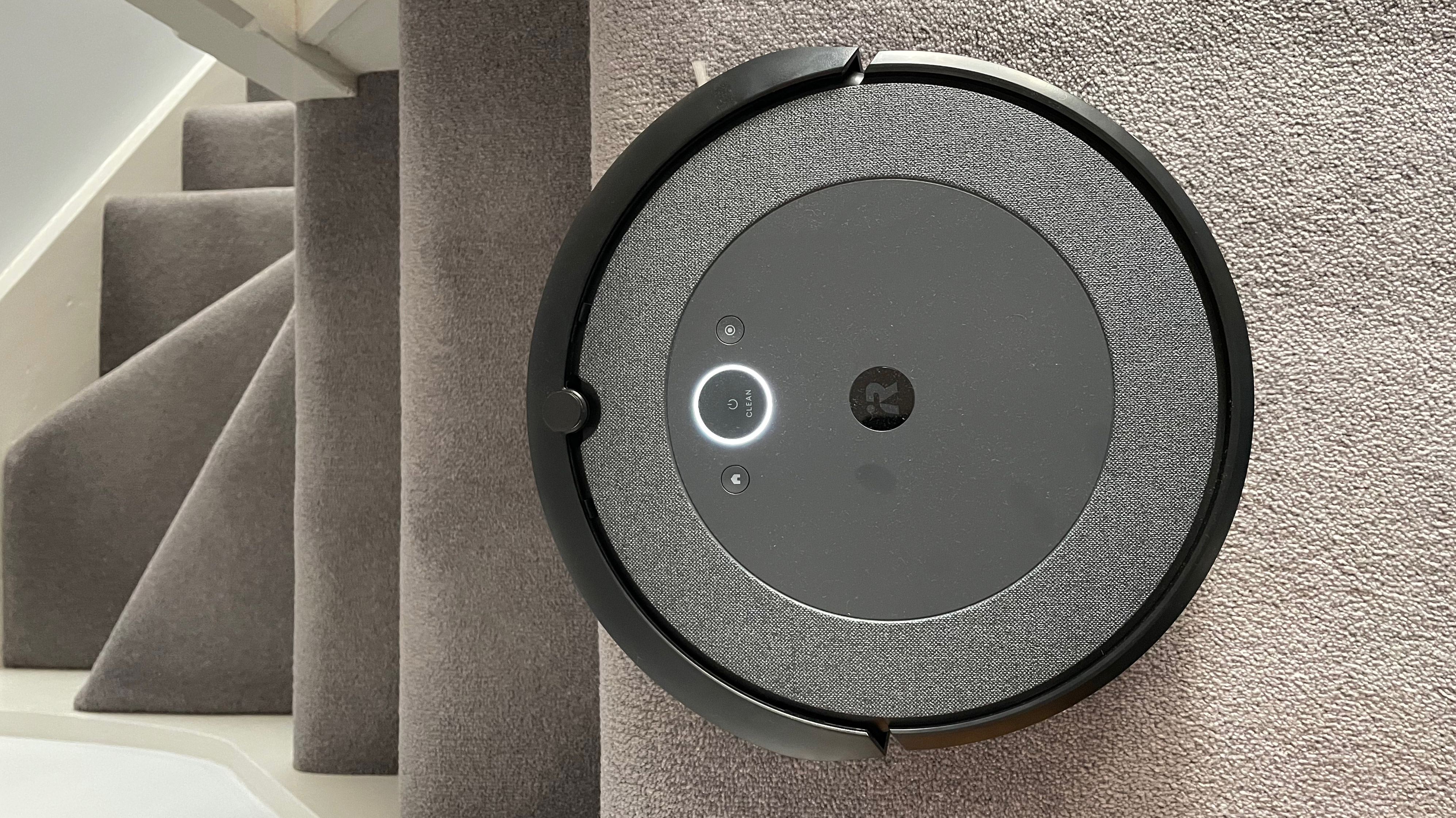 The iRobot Roomba i3 Plus cleaning near a flight of stairs