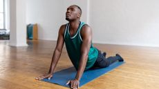 Man doing the cobra pose on an exercise mat