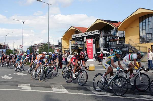 The peloton passes the Fausto Coppi museum.