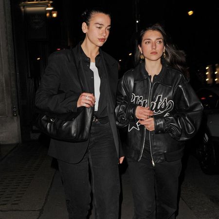 Dua Lipa wears stove pipe jeans with square-toe boots.