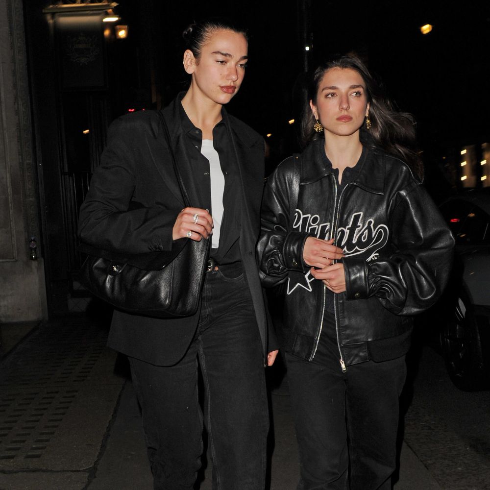 Dua Lipa wears stove pipe jeans with square-toe boots.