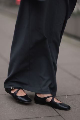 a woman wears a long black skirt with criss cross mary janes like Jennifer Lawrence's while walking around Germany