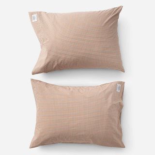 A rust colored gingham pattern pillowcase