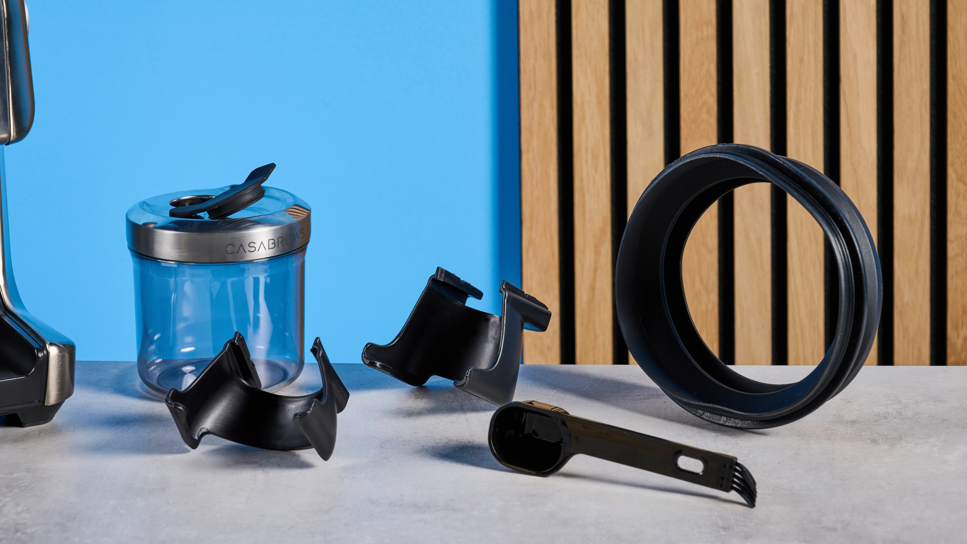 the casabrews tornado coffee grinder in silver showing the LED screen, grind adjustment dial, and photographed against a blue background