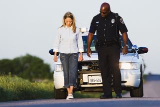 A woman is asked by a police officer to walk a straight line.