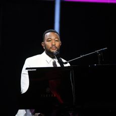 John Legend performs sat at a piano.