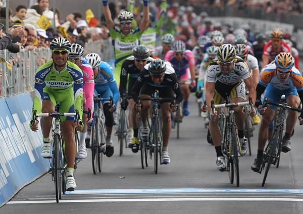 As Daniele Bennati crosses the line, one of his Liquigas-Doimo teammates celebrates from behind.