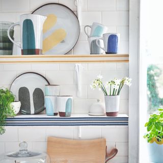 Open kitchen shelving display decorated with dinnerware