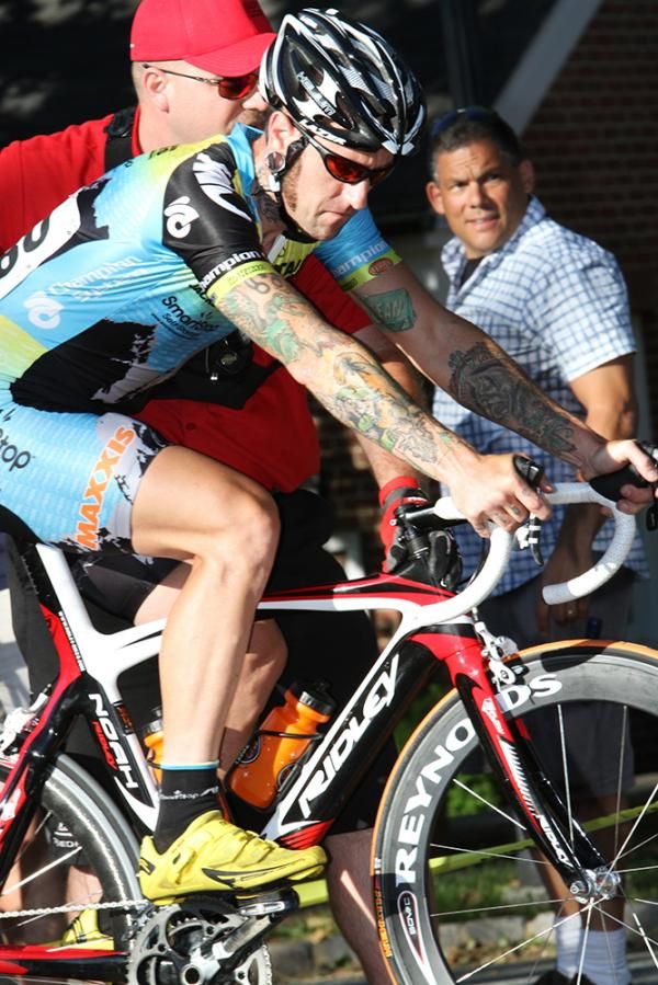 Adam Myerson (Team Mountain Khakis presented by Maxxis) makes a pit stop after a crash and picks up a new wheel.