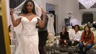 Ashley Adionser tries on a wedding dress as Marissa George and her family look on, in 'Love is Blind' season 7.