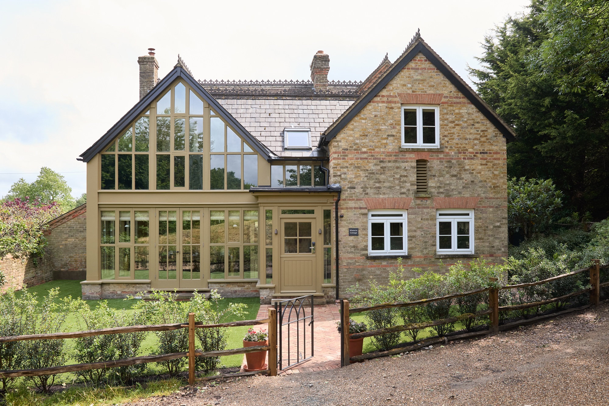 the exterior of a cottage with a glass extension