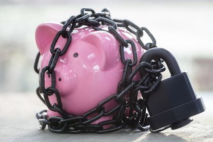 Pink piggy bank wrapped up in lock and chains