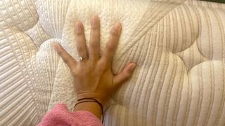 A hand pressing down on the Nolah Evolution 15" mattress