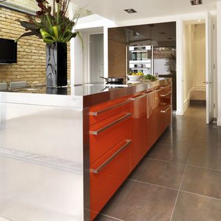 kitchen area with orange kitchen counter and bricked wall
