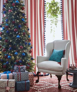 Christmas tree with white armchair and striped curtains