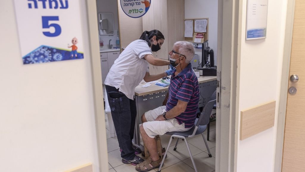 Pirmadienį Tel Avive, Izraelyje, Clalit Health Services klinikoje vyresnio amžiaus gyventojas gavo trečią Pfizer-BioNTech Covid-19 vakcinos dozę.  2, 2021 m.