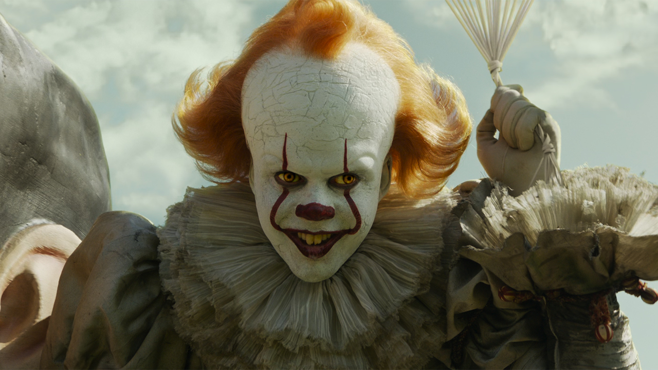 Bill Skarsgard as Pennywise on the Paul Bunyan statue in IT: Chapter 2