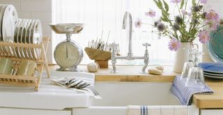 white kitchen sink with drying rack with washing up done