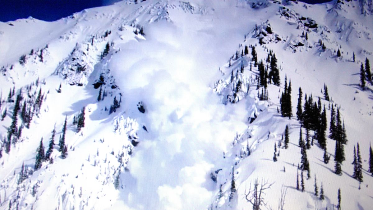 An avalanche makes its way down a snow-covered mountain