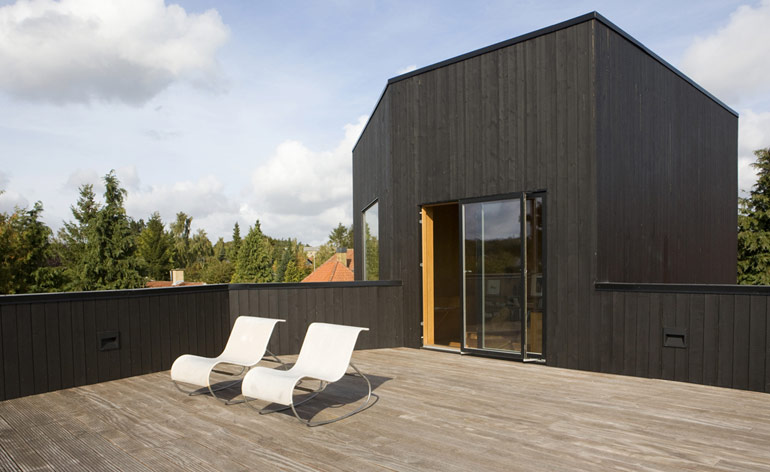 The roof terrace at the villa is very spacious and can be accessed from the study. Two white lounge chairs are set on the roof deck.